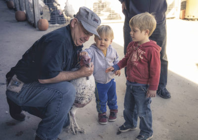 Jim Green and two young children petting a turkey